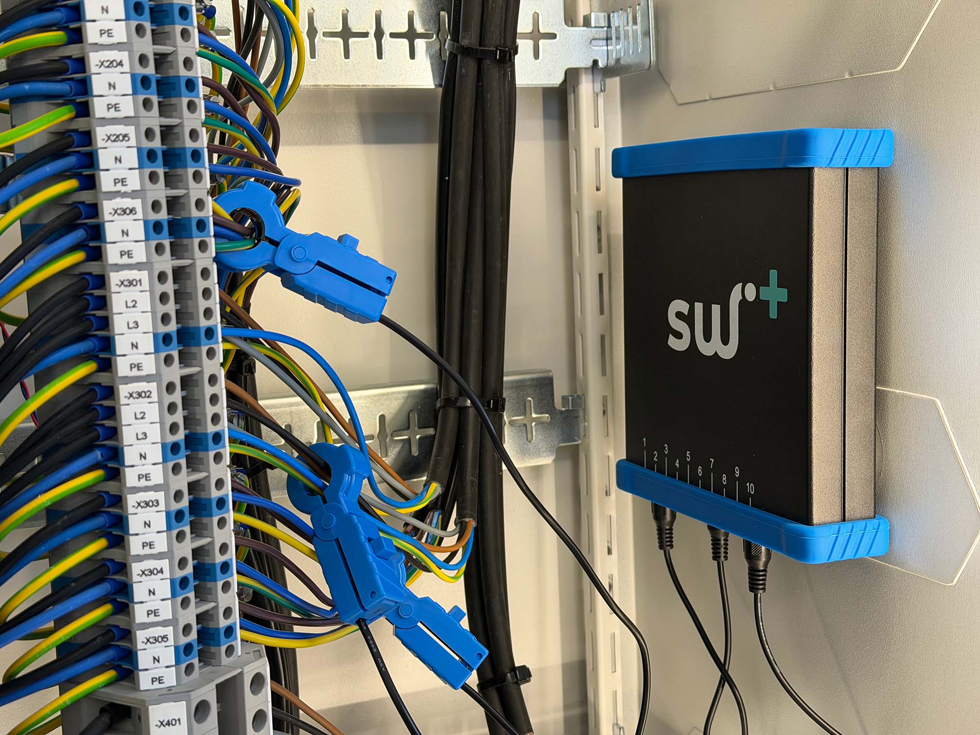 Dense electrical panel installation with cables, blue cable clips, and yellow labels